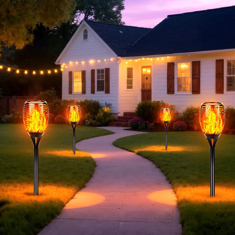 Lit Solar Torch Lights Outdoor With Realistic Flickering Flame 96 LED High Brightness 43 Inch Tall along a garden pathway