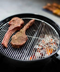 Slow N Sear Original Charcoal Basket For Weber 22 Inch Kettle Two Zone Smoker Attachment on grill with steaks.