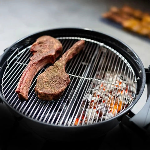 Slow N Sear Original Charcoal Basket For Weber 22 Inch Kettle Two Zone Smoker Attachment on grill with steaks.