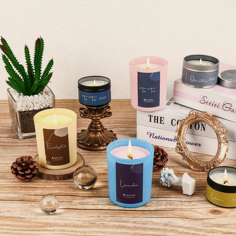 Colorful candles displayed with a frame, pine cones, and plant, showcasing a Beginner Friendly DIY Soy Candle Making Kit With Melting Pot.