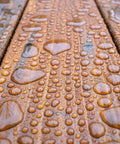 Close-up of water droplets on wood showing All In One Wood Stain And Sealer For Outdoor Wood Projects Semi Transparent Waterproof Finish In Cedar Tone Protects All Wood Types From Moisture Prevents Graying Extends Exterior Wood Life 1 Gallon protection