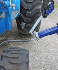 Lincoln 1147 lever-action manual grease gun with 18-inch whip hose and coupler mounted on blue agricultural equipment