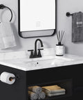 Installed matte black 4-inch centerset bathroom sink faucet with two handles; includes pop-up drain and supply hoses.