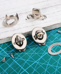 Front view: two silver marine twist-lock fasteners with eyelet studs and mounting screws