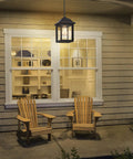Rugged Outdoor Porch Chandelier With Seeded Glass Hanging Lantern in Sand Black illuminating a cozy front porch seating area.