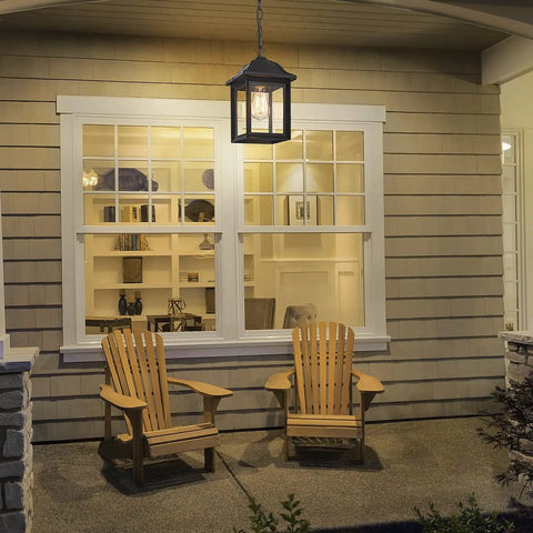 Rugged Outdoor Porch Chandelier With Seeded Glass Hanging Lantern in Sand Black illuminating a cozy front porch seating area.