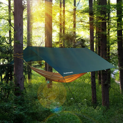 Waterproof Camping Tarp 10x10 Feet Rain Fly Ultralight Portable With UV Protection set up over a hammock in a forest.