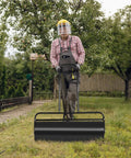 Person using Heavy Duty Steel Lawn Roller 17 Gallon Push Pull Sod Roller Water And Sand Filled 36 By 12 Inch for Lawn Leveling