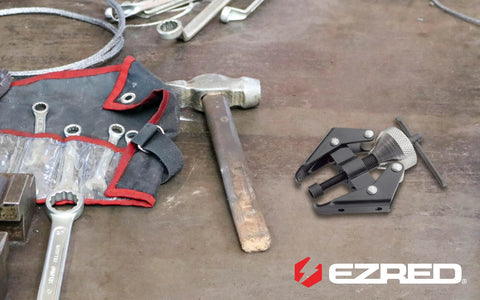 Side view of EZ RED BK706 battery terminal and wiper arm puller on a workbench with wrenches.