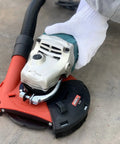 Universal 7 Inch Dust Shroud for Angle Grinders with Vacuum Hose Adapter in use, fits most major brands, concrete surface shown