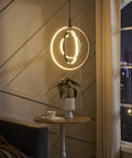 Black Modern 3 Ring Dimmable Pendant Chandelier for Dining Room, Kitchen Island, and Living Room, lit near window.