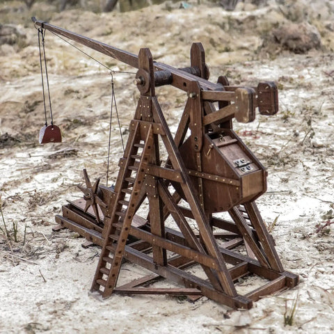 Mini Counterweight Trebuchet Model Kit for Adults, 3D Wooden Puzzle Siege Engine, DIY STEM Project, Tabletop Toy, Alder Veneer Plywood Build, Ages 14 Plus, Totally Fun Historical Replica, side view on sand