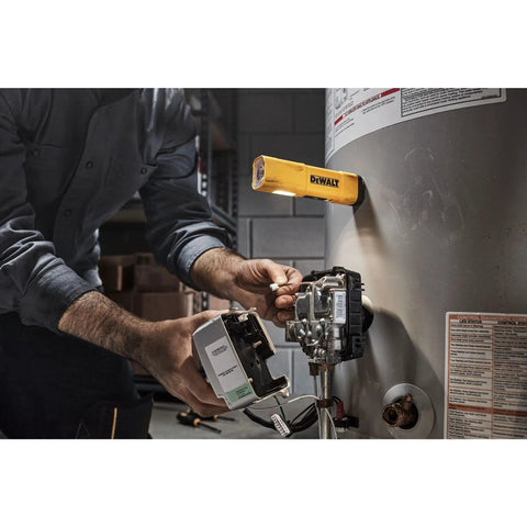 USB-C Rechargeable LED Flashlight With Magnetic Jobsite Light attached to a water heater, illuminating a workspace