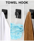 Matte Black 4 Piece Bathroom Hardware Set Including 24 Inch Towel Bar Towel Ring Toilet Paper Holder And Towel Hook Wall Mounted Rustproof Premium Metal, showing towel hook installed with towels and loofah.