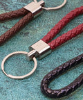 Premium Braided Pu Leather Key Fob With Solid Metal Hardware For Daily Grind Fly Woven Keychain Ring Holds car and home keys in black, brown, and red.