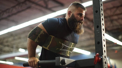 Man using Bench Press Assist Strap With Level 3 Tension Red Powerlifting Gear Lets You Press 10 To 15 Percent More Weight Reduces Shoulder Strain Improves Form For Heavy Lifts And Gains Big for dips in a gym setting.