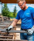 Person in blue shirt wearing Six Pairs Heavy Duty Work Gloves With Sandy Nitrile Coating, holding metal rods at construction site.