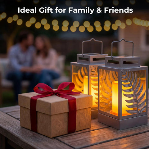 Outdoor Solar Lanterns With Flickering Flame 2 Pack Rustproof Metal LED Lights on patio table with gift box, blurred couple in background.
