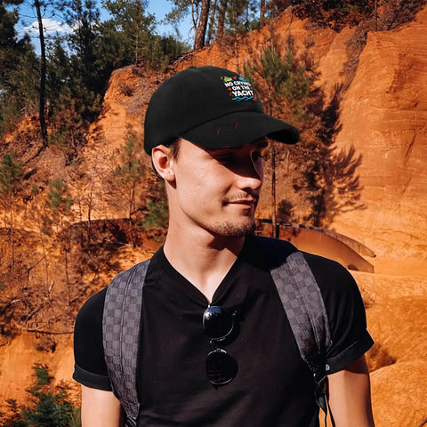 Man wearing Adjustable Mens Hat With Front Artwork Ventilated Mesh Crown, standing outdoors against a rocky backdrop.