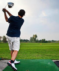 Golfer practicing swing on mat using Five Pack 1.5 Inch Rubber Tee Adapters For Indoor Outdoor Golf Practice Mats White Tee Holder Set