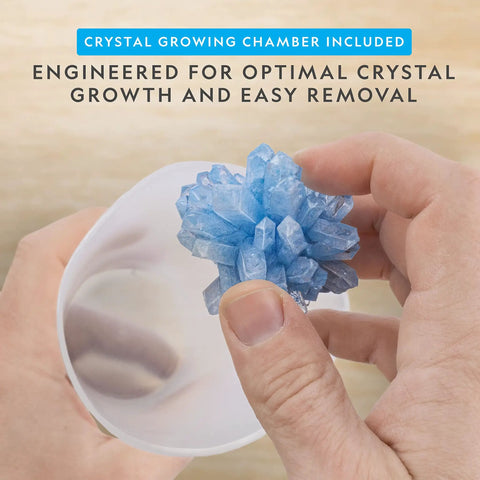 Hands holding a blue crystal from Awesome Crystal Growing Kit For Kids With Light Up Display Stand Grow Three Vibrant Crystals In Blue Purple And Green STEM Science Toy For Ages 8 To 12 Includes Gems Cool Gift For Curious Girls And Boys.