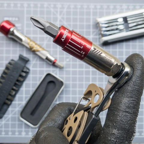 Close-up of Pocket Size Precision Torque Driver With Mini Indexed Wrench And Variable Torque Control, accessories in background.