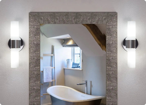 Dual 14 Inch Modern Wall Sconce With Frosted Glass Cylinder Shades In Chrome Finish installed beside a bathroom mirror