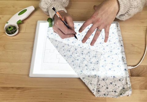 Hands using a Portable LED Light Pad For Crafting And Quilting 10 By 13 Inch, Ultra Bright Four Level Illumination For Clear Tracing And Cutting.