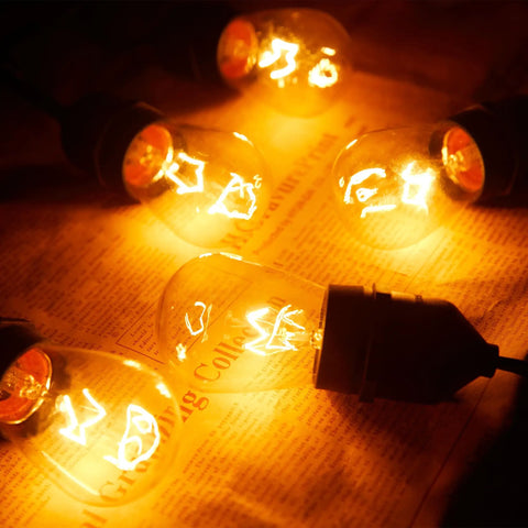 Bulk 20 Pack S14 Clear Light Bulbs 11W Warm Glow With E26 Medium Base For Indoor And Outdoor Use, glowing on paper surface