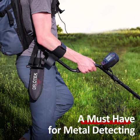 Man using a Heavy Duty Metal Detecting Shovel With Belt Sheath Double Serrated Edge Digging Tool in a grassy field.