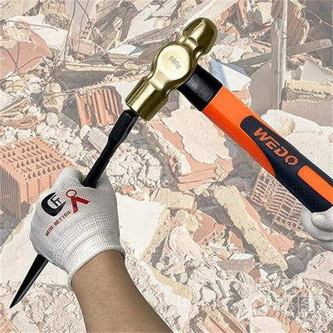 Hand holding ball pein hammer from 36 Piece Non Sparking Tool Set With Double Open End Wrenches And Combination Wrenches Pipe Wrenches Ball Pein Hammer Aluminum Bronze Die Forged Corrosion Resistant DIN Standard BAM Certified Heavy Duty Professional Grade Kit with rubble in background