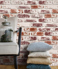 Lifestyle setting with Red Brick Peel And Stick Wallpaper For Walls Waterproof Self Adhesive Removable Faux 3D Brick Backsplash And Accent Covering No Glue Needed Diy Friendly 17.7in W 393in L 48.4 Sq Ft behind chair and pillows.