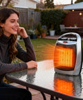 Effortless Space Heater With Built In Fan For Small Rooms on outdoor table, emitting warm glow, silver design visible