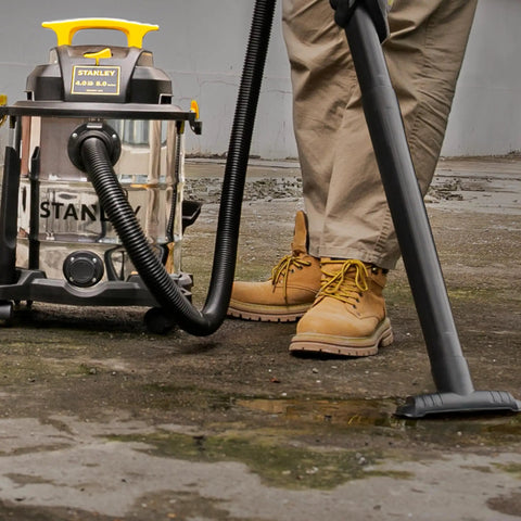 Person using 8 Gallon Wet Dry Vacuum With 4 HP Peak Motor, Heavy Duty Shop Vac With Attachments, on workshop floor.
