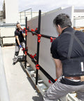 Two workers using Heavy Duty Slab Conveyor For Transporting Ceramic Sheets And Large Format Tiles on an outdoor worksite.