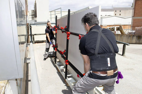 Two workers using Heavy Duty Slab Conveyor For Transporting Ceramic Sheets And Large Format Tiles on an outdoor worksite.