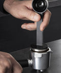 Hand using a tamper on a portafilter for the Semi Automatic Espresso Coffee Maker With Built In Steam Wand And High Pressure Pump For Rich Creamy Shots This Sleek Black Home Barista Setup Kicks Serious Flavor And Runs Smooth Every Time You Hit Brew.