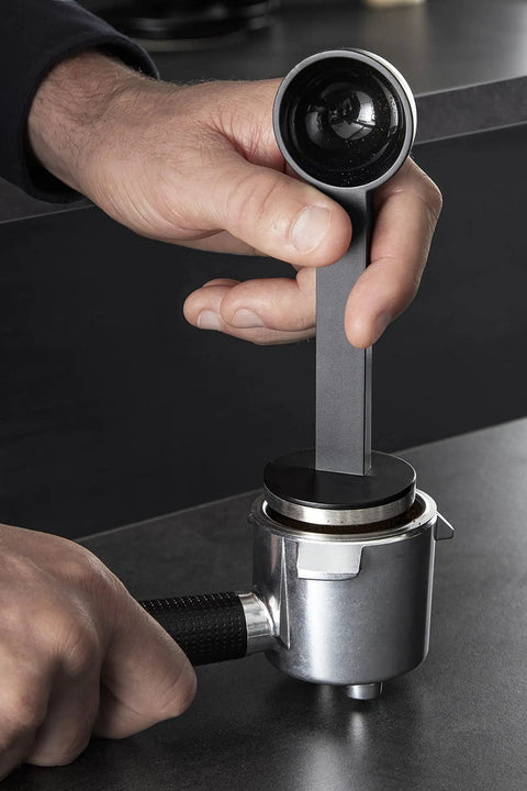 Hand using a tamper on a portafilter for the Semi Automatic Espresso Coffee Maker With Built In Steam Wand And High Pressure Pump For Rich Creamy Shots This Sleek Black Home Barista Setup Kicks Serious Flavor And Runs Smooth Every Time You Hit Brew.