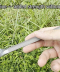 Hand holding Ultra Lightweight Titanium Long Handle Spork With Polished Bowl For Camping And Hiking over grass