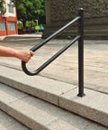Person holding Sturdy Metal Outdoor Stair Handrail For One To Three Steps Single Post Wrought Iron Design Matte Black Rust Proof Railing