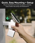 Hand mounting No Sweat Solar Security Camera with solar panel on a wall for easy installation, showcases battery-powered setup.