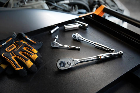 Three Piece Teardrop Ratchet Set With Quick Release 90 Tooth Narrow Low Profile Head For Tight Spots Fits One Quarter Inch Three Eighths Inch And One Half Inch Drive Ball Detent Socket Retention Keeps Sockets Locking In. chrome ratchet set on workbench with gloves
