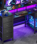 47 Inch Gaming Desk With Power Outlets And LED Lights Reversible Computer Desk With Five Fabric Storage Drawers Monitor Stand For Home Office And Study Setup Vibe Black, featuring RGB lighting and gaming setup.