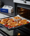 Chicken and veggies on tray lined with Pre Cut Aluminum Foil Sheets 12x12 Pop Up Box Of 500 For Easy Food Wrapping in home kitchen oven.