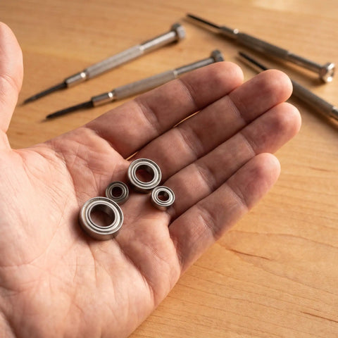 Beefed Up RC Vehicle Bearing Kit 30 Pcs Fits WLtoys One Fourteen 144001 Upgrade Kit With Precision Metal Bearings For Sturdier Wheels And Smoother Rides In RC Cars hand holding four metal bearings
