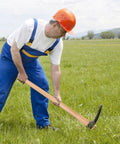 Worker using Two Pack Beech Wood 35 Inch Pick Axe Handle Replacement For Heavy Duty Pickaxe And Mattock Tools in a field.