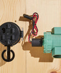 Battery Powered Outdoor Sprinkler Timer For Yard With Four Valve Control, 1 Inch FPT Jar Top Valve next to wiring on wood surface