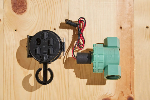 Battery Powered Outdoor Sprinkler Timer For Yard With Four Valve Control, 1 Inch FPT Jar Top Valve next to wiring on wood surface