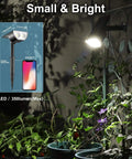 Solar Spotlight Pack Outdoor 12 LED IP67 Waterproof Dusk To Dawn Auto On Off 2In1 Adjustable Solar Powered Wall Lights illuminating plants.