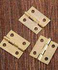Three brass 18x16mm hinges on wood, part of 20 Pack Decorative Jewelry Box Hinges For Small Wood Boxes 18x16mm Mini Cabinet Hinges With Screws